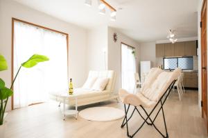 ein Wohnzimmer mit weißen Stühlen und einem Tisch in der Unterkunft Kuwana - House - Vacation STAY 82016v in Genroku