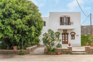 a white house with a tree in front of it at Cyclades Beach in Platis Yialos Sifnos