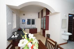 a kitchen with a table with white flowers on it at Krishna Vibe Service Apartment in Tiruchchirāppalli