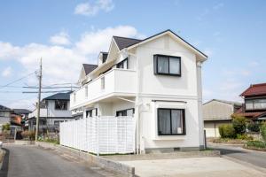 Ein weißes Haus an der Seite einer Straße in der Unterkunft Kuwana - House - Vacation STAY 82016v in Genroku