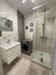 a bathroom with a shower and a washing machine at Appartement le Jules VERNE in Le Crotoy +10 photos