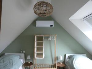 a attic bedroom with two beds and a shelf at Casa Del Faro in Westkapelle