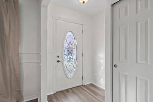 a white hallway with a door with a window at Dublin Blue Haven - Home for 12 in Dublin