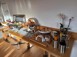 une table contenant de nombreux types de denrées alimentaires différents dans l'établissement Hotel Garni Postigliun Andiast, à Andest