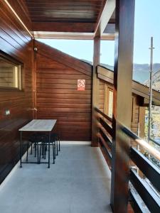 Zimmer mit einem Tisch und Stühlen auf einem Balkon in der Unterkunft Exclusiva Cabaña en Incles - Vistas al Valle & Pistas de Ski Grandvalira - Free Parking in Canillo
