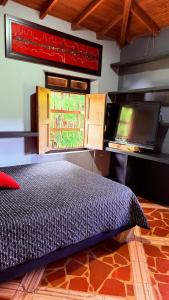 a bedroom with a bed and a window at Finca 5 Continentes - Cerca MatroCable ARVI in Guarne