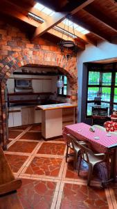 a kitchen with a table and a brick wall at Finca 5 Continentes - Cerca MatroCable ARVI in Guarne