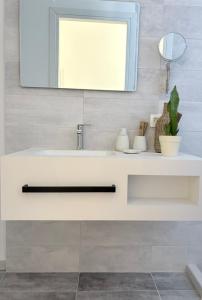 a bathroom with a white sink and a mirror at Athina's Cozy Guest House in Kamisianá