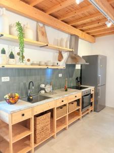 a kitchen with a sink and a refrigerator at Athina's Cozy Guest House in Kamisianá +39 photos