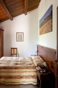 ein Schlafzimmer mit einem Bett mit einem hölzernen Kopfteil in der Unterkunft La Rosa Nel Bicchiere in Soveria Mannelli