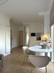 une cuisine et un salon avec une table et des chaises dans l'établissement Let's Sea SPA - Premium Apartamenty z ogródkiem, przyjazne zwierzętom, à Gąski