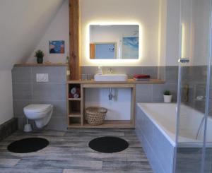 ein Badezimmer mit Waschbecken, Toilette und Spiegel in der Unterkunft Wohnung in Gießelrade mit Großem Garten - b48578 in Ahrensbök