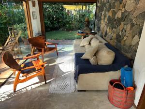 ein Wohnzimmer mit einer Couch und einem Tisch und Stühlen in der Unterkunft Vila dos Tangarás, Casa 2 Boutique Riacho - 30m do mar in Toque Toque Grande