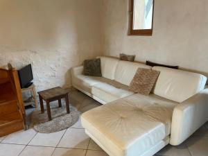 ein Wohnzimmer mit einer weißen Couch und einem Tisch in der Unterkunft 70m2 dans une ferme en Isère in Le Pont-de-Beauvoisin