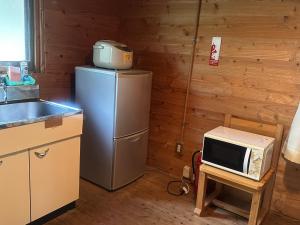 une cuisine avec un réfrigérateur et un micro-ondes sur un tabouret dans l'établissement Sky Lodge Gingamura - Vacation STAY 84333v, à Shironita 4 autres photos