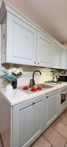 une cuisine blanche avec des armoires blanches et un évier dans l'établissement Appartamento Perla Marina, à Sottomarina