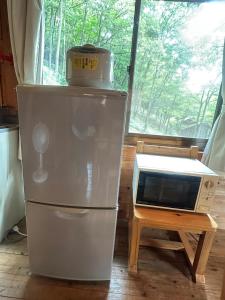 un réfrigérateur et un micro-ondes dans une pièce avec une table dans l'établissement Sky Lodge Gingamura - Vacation STAY 84483v, à Shironita