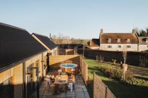 an outdoor patio with a hot tub next to a house at Adam in Newent