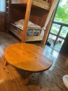 une table en bois dans une chambre avec des lits superposés dans l'établissement Sky Lodge Gingamura - Vacation STAY 84488v, à Shironita