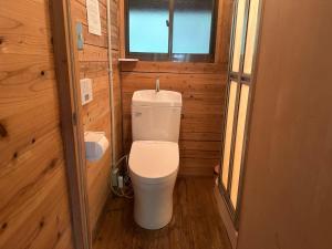 une petite salle de bain avec toilettes dans une cabane en bois dans l'établissement Sky Lodge Gingamura - Vacation STAY 84488v, à Shironita