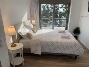 a bedroom with a white bed and a window at Voula Pool & Sea View & Beach home B1 in Athens +73 photos
