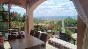 a table and chairs on a balcony with a view at къща за гости villa Jurta in Avren