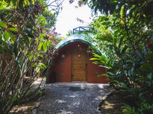 a small building with a wooden door in a garden at Nowhere in Bocas del Toro