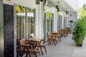 une rangée de tables et de chaises sur une terrasse dans l'établissement Dacha Thoddoo White Sand, à Thoddoo