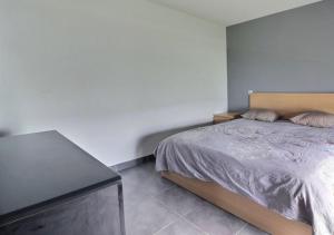 Schlafzimmer mit einem Bett und einem schwarzen Tisch in der Unterkunft Appartement Cosy in Le Crès