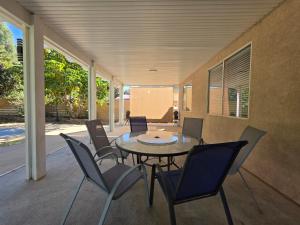 eine Terrasse mit einem Glastisch und Stühlen in der Unterkunft Newly Listed Family Friendly Fontana House in Fontana