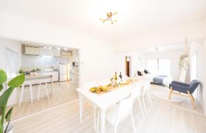 eine weiße Küche und ein Wohnzimmer mit einem Tisch und Stühlen in der Unterkunft Yokkaichi - House - Vacation STAY 85333v in Kawashima