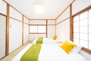 2 Betten in einem Zimmer mit Fenstern in der Unterkunft Yokkaichi - House - Vacation STAY 85333v in Kawashima