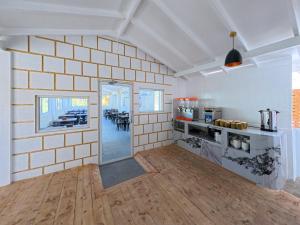a kitchen with white walls and a wooden floor at Dacha Thoddoo White Sand in Thoddoo