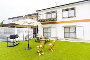 eine Terrasse mit Tisch und Stühlen und einem Sonnenschirm in der Unterkunft Yokkaichi - House - Vacation STAY 85333v in Kawashima