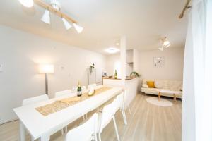 eine weiße Küche mit einem Esstisch und einem Sofa in der Unterkunft Kuwana - House - Vacation STAY 85367v in Maegasu-shinden