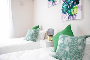 1 Schlafzimmer mit 2 Betten und grünen und weißen Kissen in der Unterkunft Kuwana - House - Vacation STAY 85367v in Maegasu-shinden