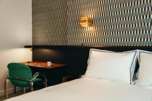 a bedroom with a bed and a chair and a table at La Villa Maurice in Brussels