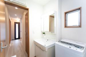 ein weißes Badezimmer mit Waschbecken und Spiegel in der Unterkunft Kuwana - House - Vacation STAY 85367v in Maegasu-shinden + 36 Fotos