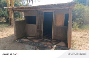 an outhouse with an open door in a field at Majimoto Bushpig Camp in Narok