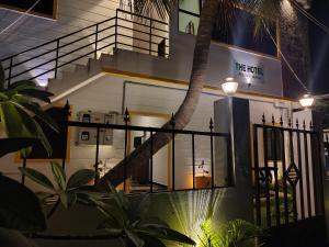 a building with a palm tree in front of it at The Hotel Eden Beach in Puducherry
