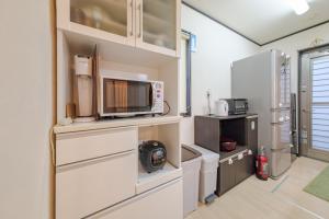 une cuisine avec des armoires blanches et un micro-ondes dans l'établissement Hachioji - House - Vacation STAY 20638, à Haijima