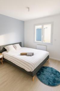 a bedroom with a large bed with a blue rug at Maison moderne 5 personnes, proche Lyon in Marcy-lʼÉtoile