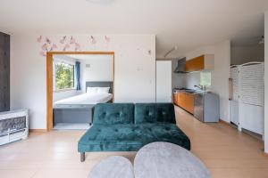 un salon avec un canapé vert et un lit dans l'établissement Abutagun - House - Vacation STAY 86202v, à Usu