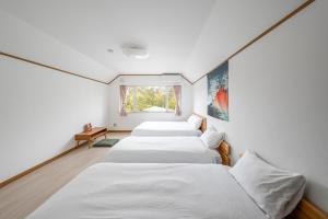 une rangée de lits blancs dans une pièce avec une fenêtre dans l'établissement Abutagun - House - Vacation STAY 86202v, à Usu