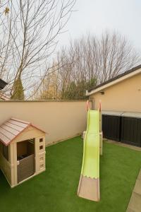 a playground with a slide and a dog house at Maison moderne 5 personnes, proche Lyon in Marcy-lʼÉtoile