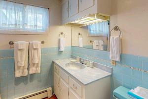 a blue tiled bathroom with a sink and a mirror at Rainbow Riverhouse in South Fork +15 photos