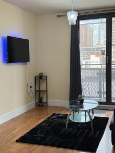ein Wohnzimmer mit einem Glastisch und einem großen Fenster in der Unterkunft Nexus - Top Floor City Views, Balcony & Parking in Birmingham