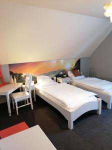 a room with two beds and a chair in it at Oberża in Czeladź