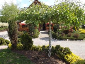 a tree in a garden with a house in the background at Oberża in Czeladź +11 photos