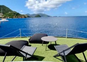 a table and chairs on the deck of a boat at Aqua Lodge, Les Saintes, Terre de Haut, Guadeloupe in Terre-de-Haut